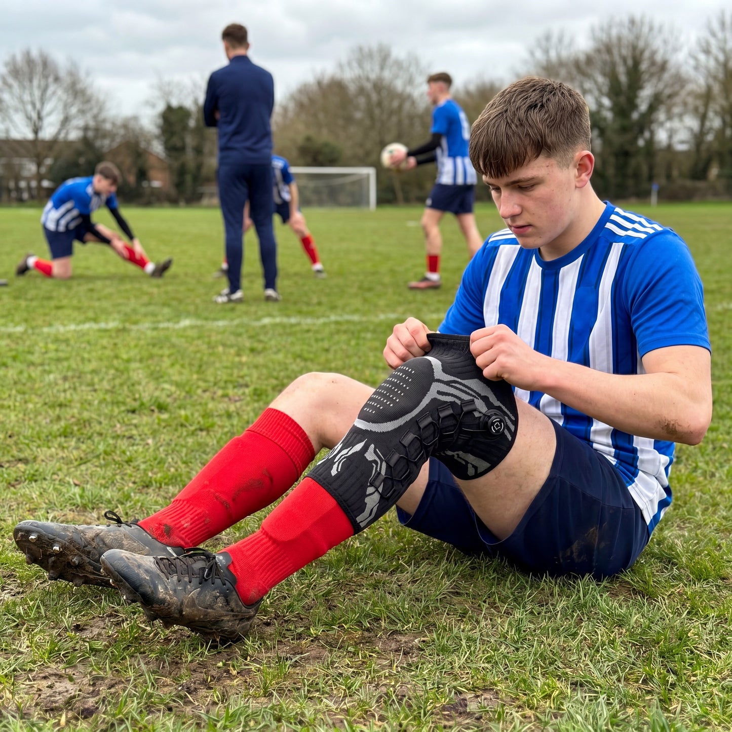 Footballer putting on adjustable knee brace
